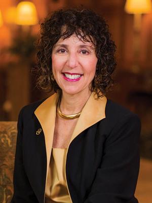 Ora Hirch Pescovitz posing for a headshot while sitting on a couch